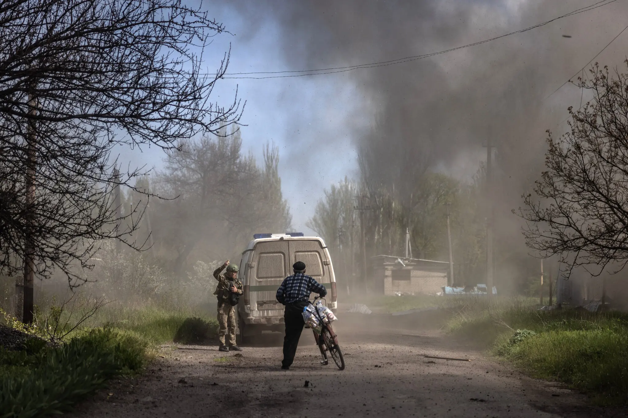 Поліцейський відводить чоловіка від вибуху. Вибух стався за кілька секунд до того, 27 квітня